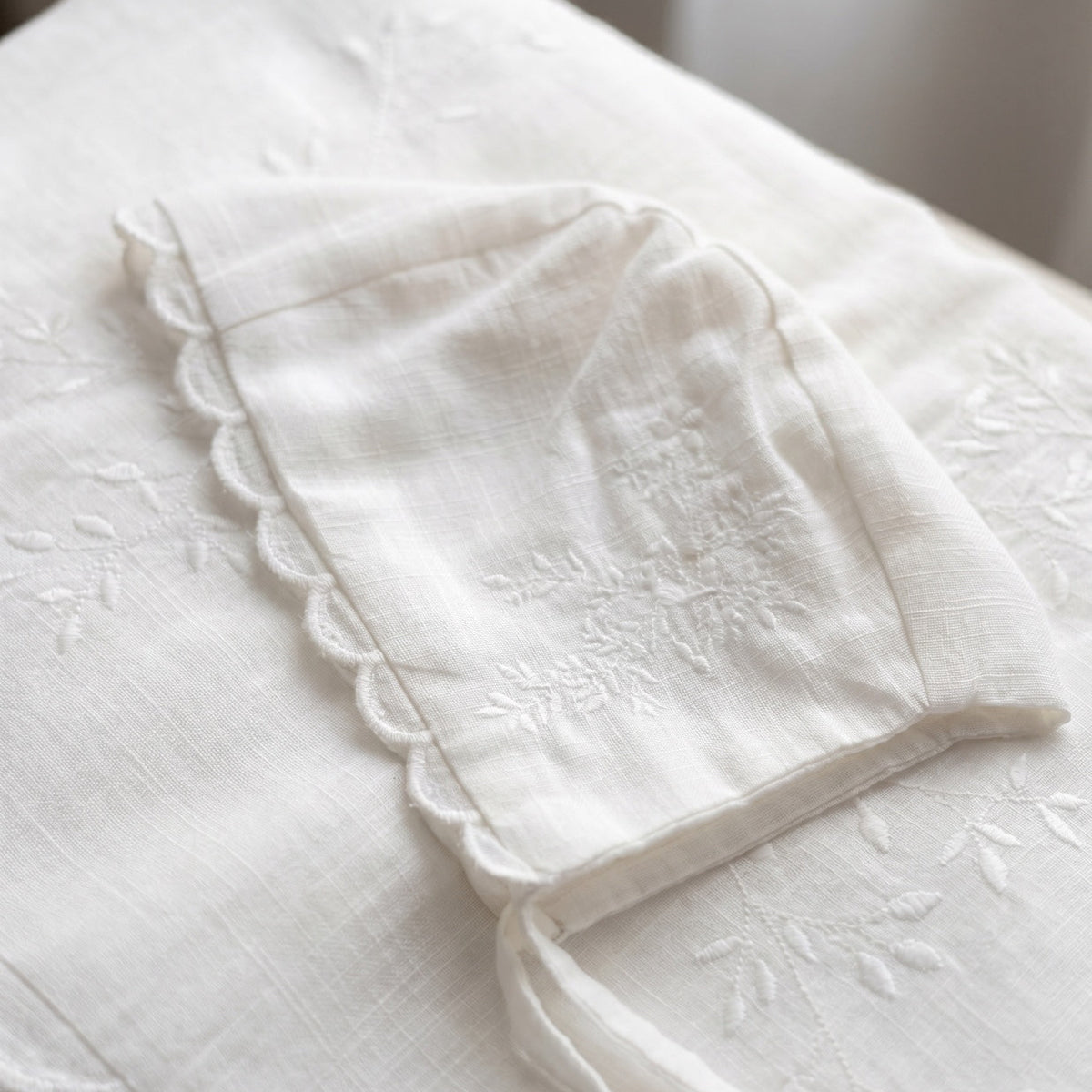Detail of the embroidered ivory cotton batiste bonnet and blanket