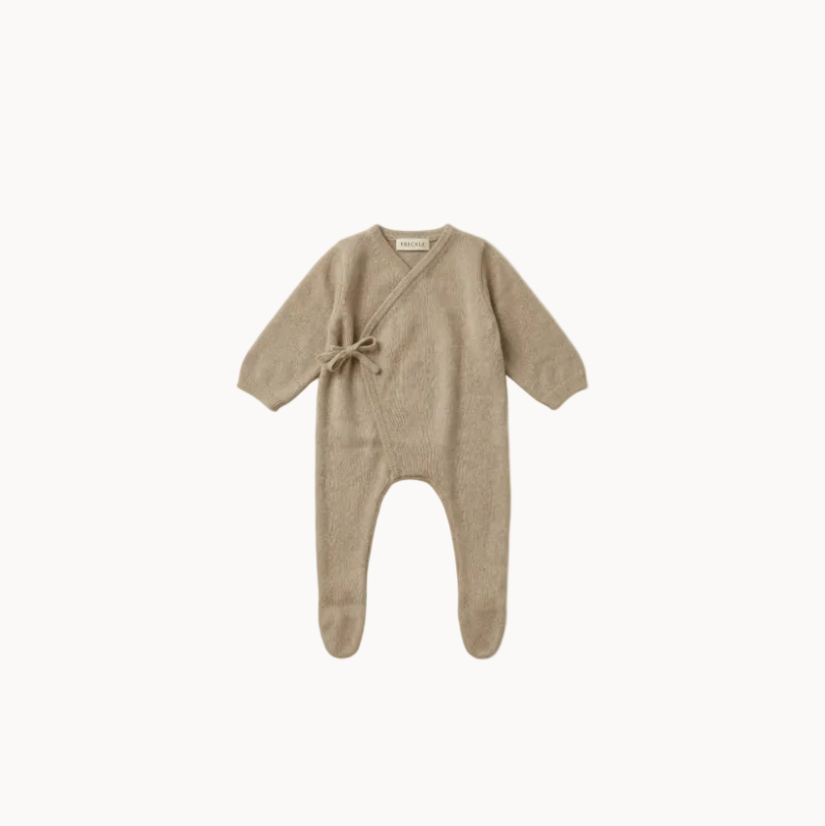Beige baby onesie with a tie detail on a white background