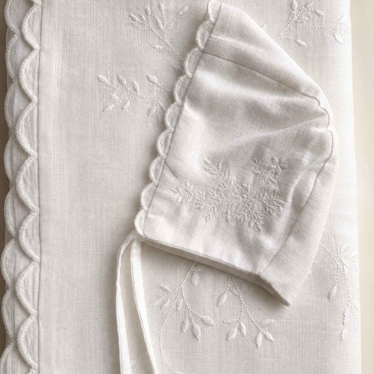 Ivory cotton batiste blanket and bonnet with floral embroidery and scalloped edges